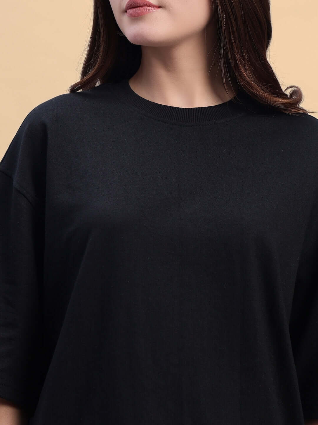 Close-up of women's Titan oversized t-shirt in black-orange, premium cotton French terry, with a focus on fabric texture and design.