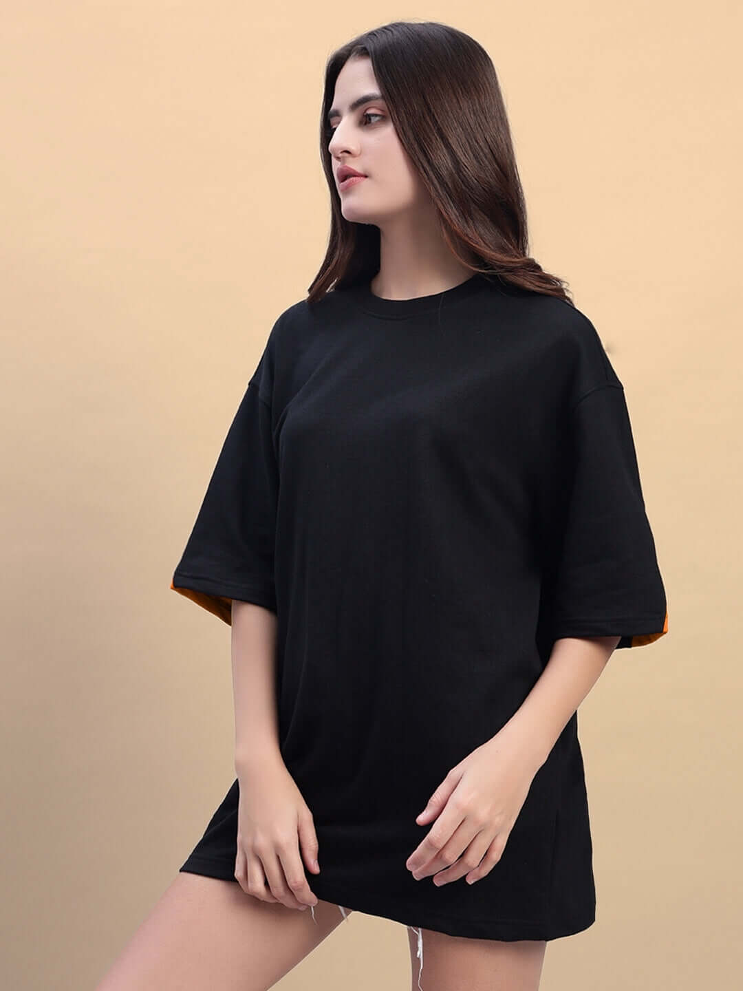 Model wearing Women's Titan Over-sized T-shirt in black-orange, made with premium cotton French Terry, showcasing its relaxed fit.