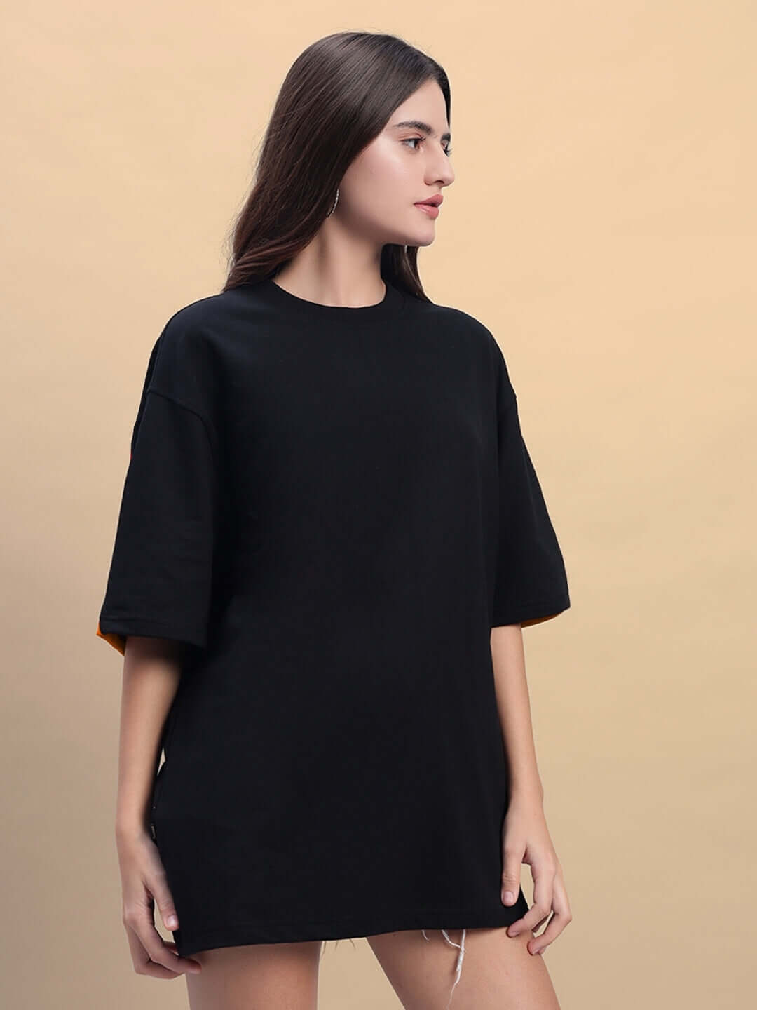 Model wearing women's Titan oversized black-orange T-shirt made of premium cotton, emphasizing its sleek design and comfort fit.