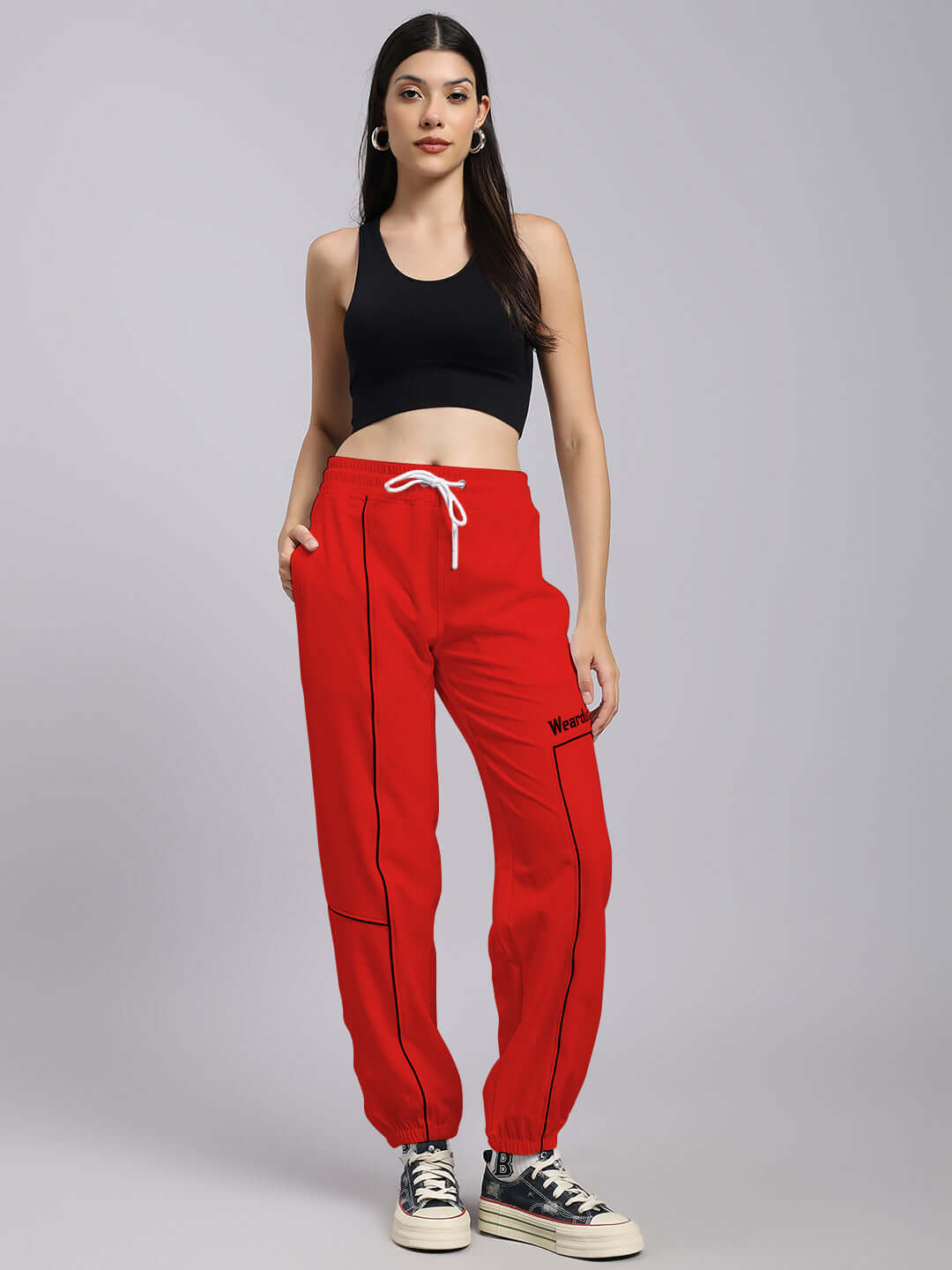 Model wearing Women's Tokyo Relaxed Fit Joggers in red, paired with a black top and sneakers. Made-to-order by DUDS.