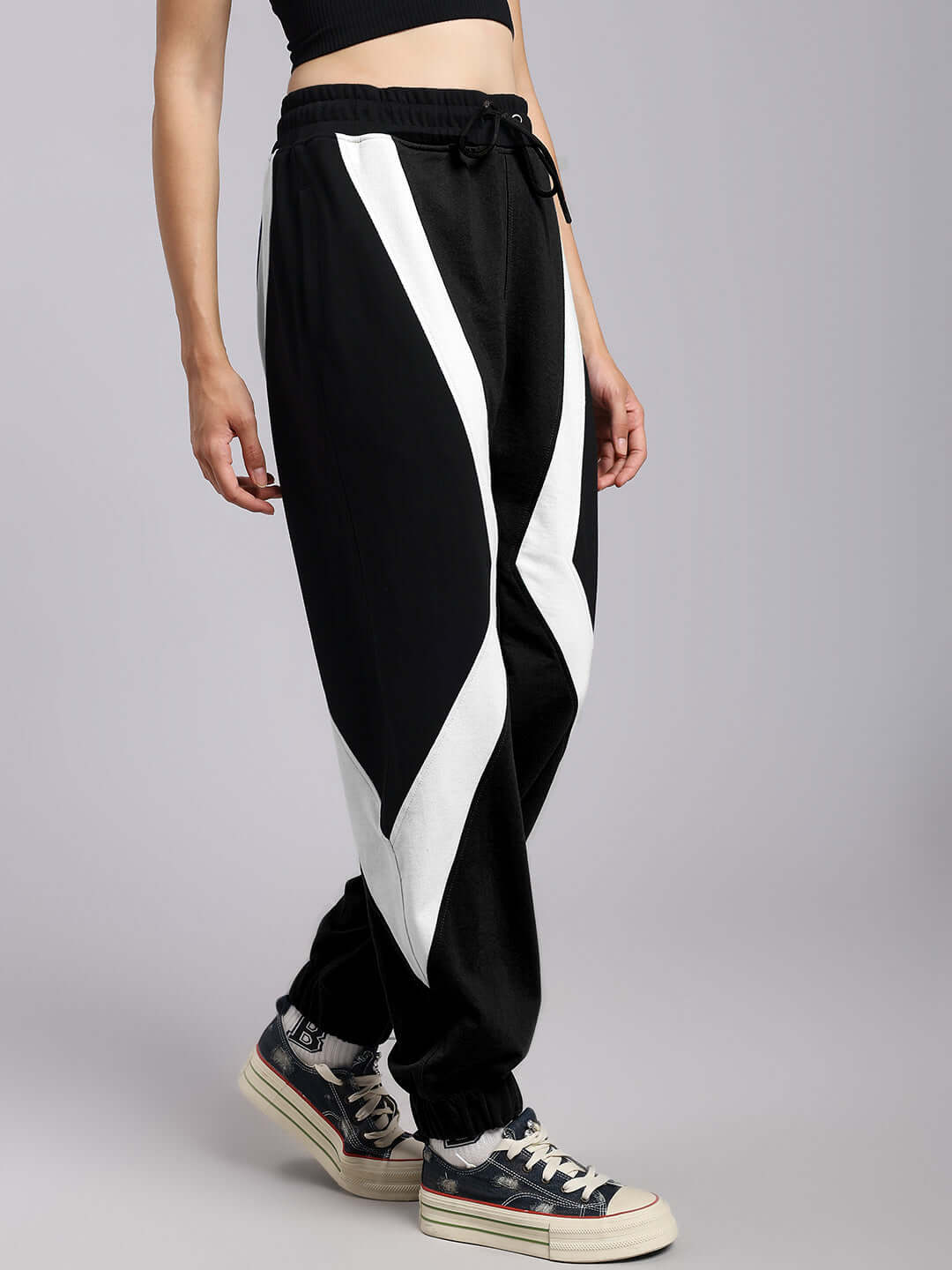 Woman wearing black and white ultra colorblock relaxed-fit joggers with custom fit option.