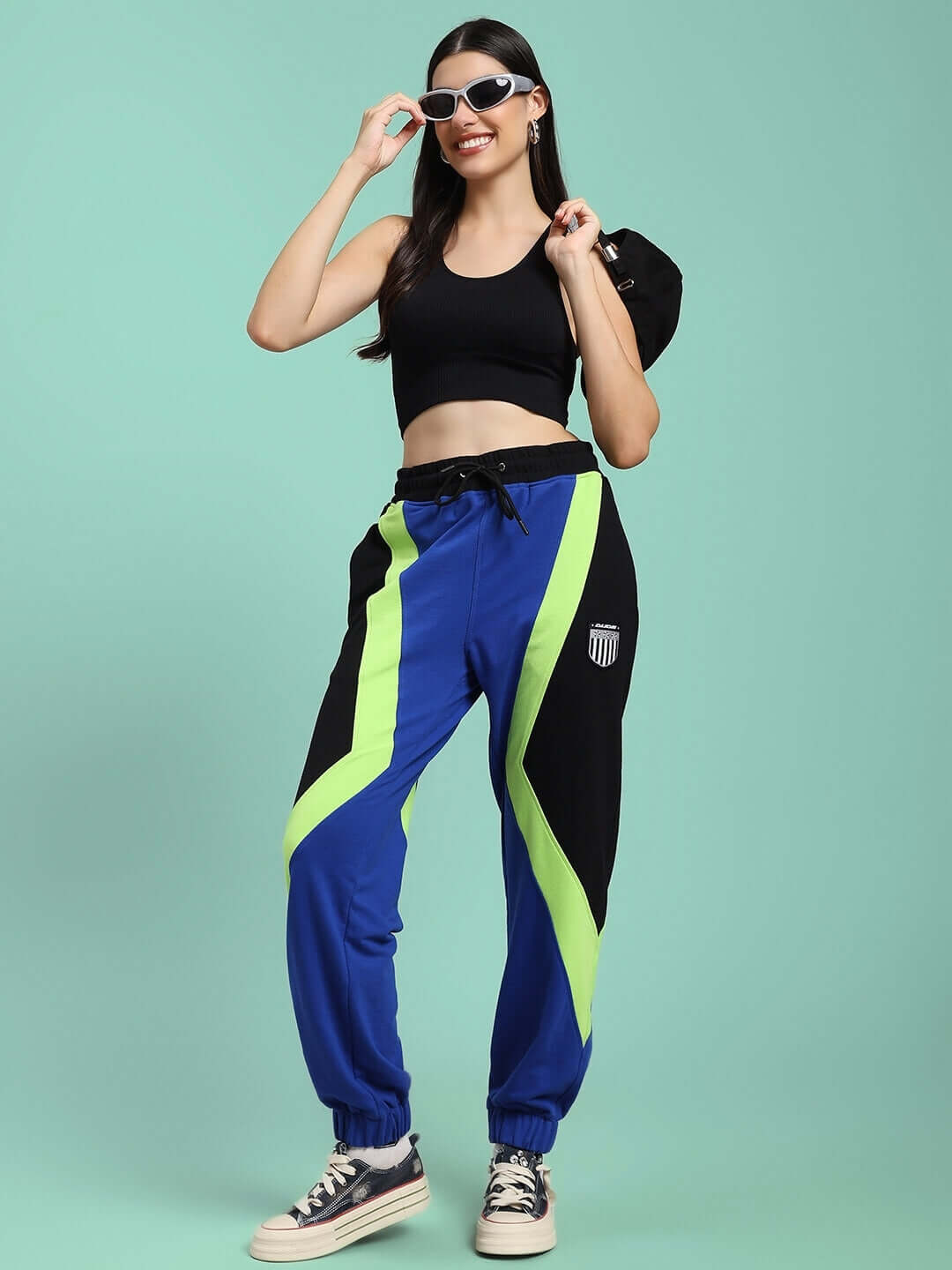 Model wearing WOMENS ULTRA COLORBLOCK RELAXED-FIT JOGGERS BLUE-BLACK with bold colorblock design in blue and black.