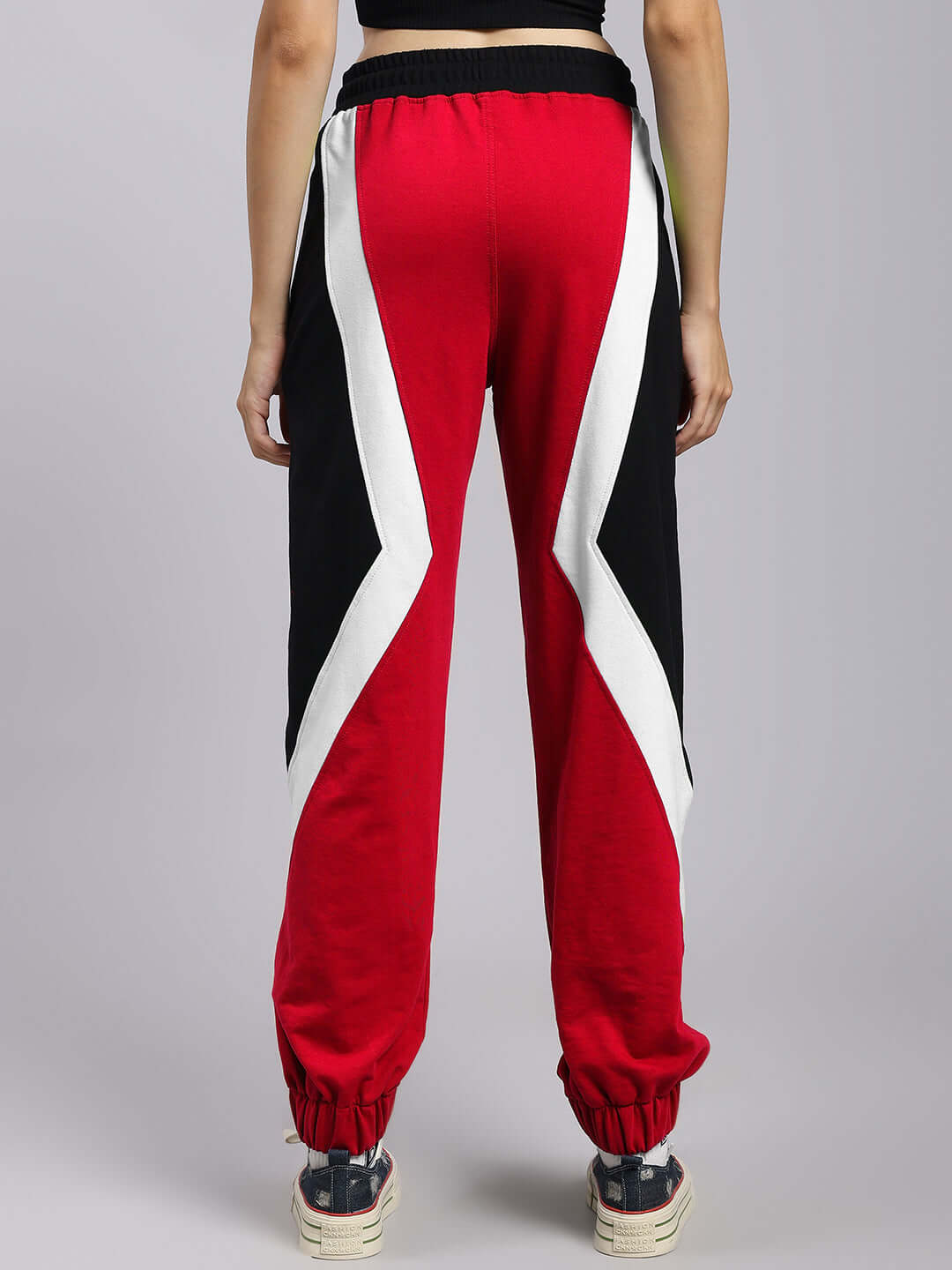 Rear view of women's red and black colorblock relaxed-fit joggers with elastic waist, showcasing modern design and comfort.