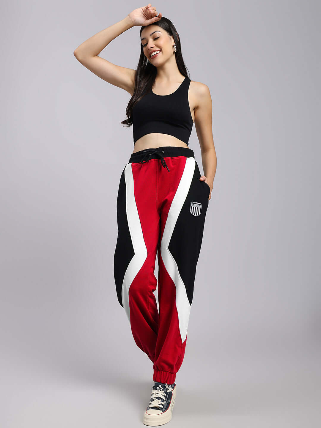 Woman wearing red-black colorblock joggers with relaxed fit, designed for comfort and style.
