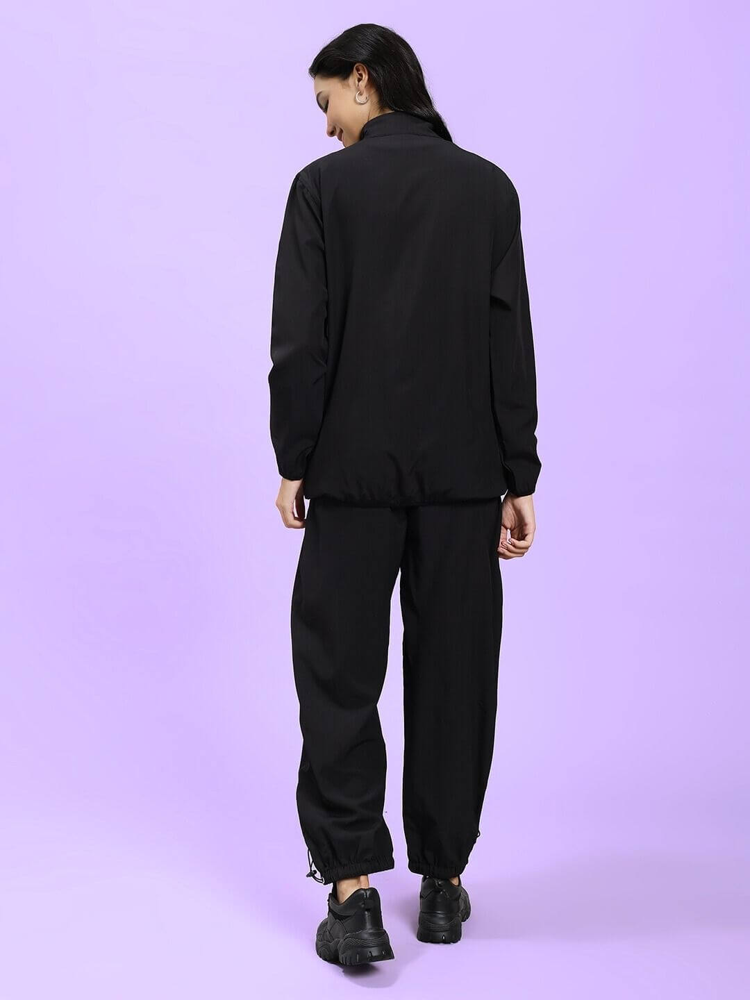 Back view of WOMEN UNISON RELAXED FIT CO-ORD SET BLACK RED on female model against a purple background
