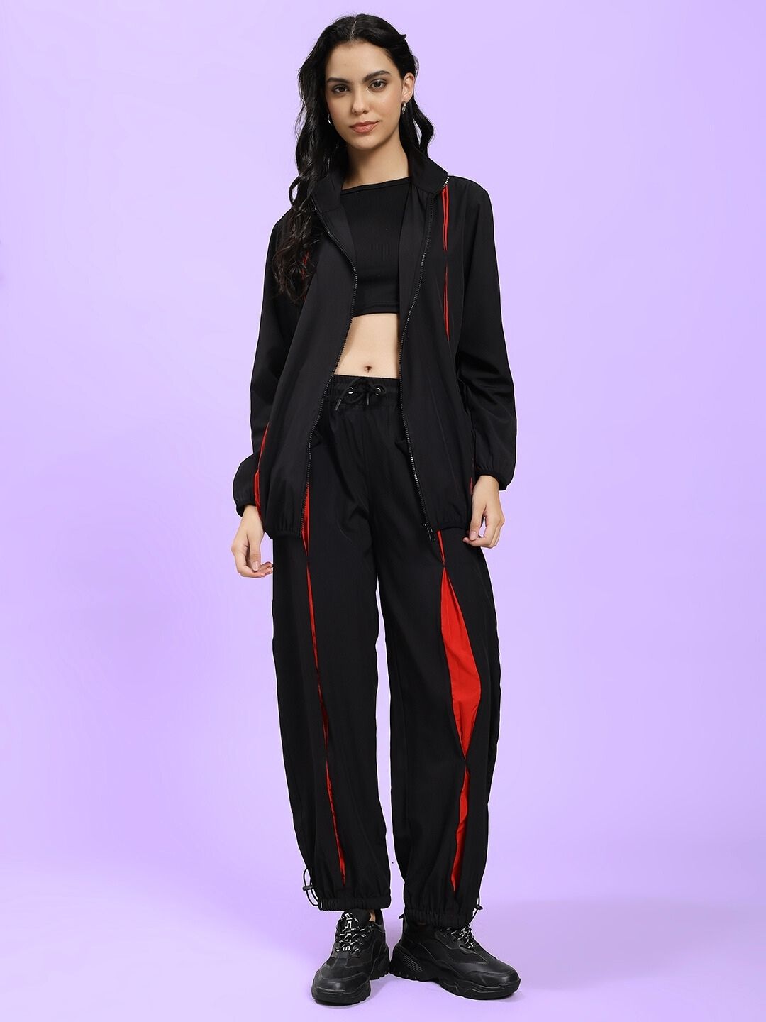 Woman wearing Women Unison Relaxed Fit Co-ord Set Black Red standing against purple background, showcasing trendy casual fashion.