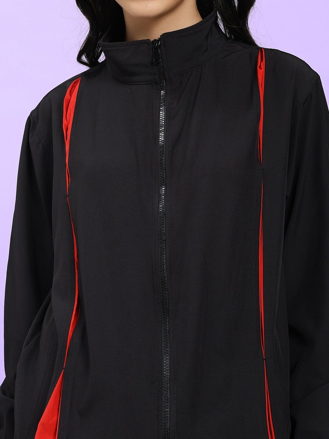Close-up of WOMEN UNISON RELAXED FIT JACKET BLACK RED with bold black and red contrast, emphasizing sleek street-style fashion.