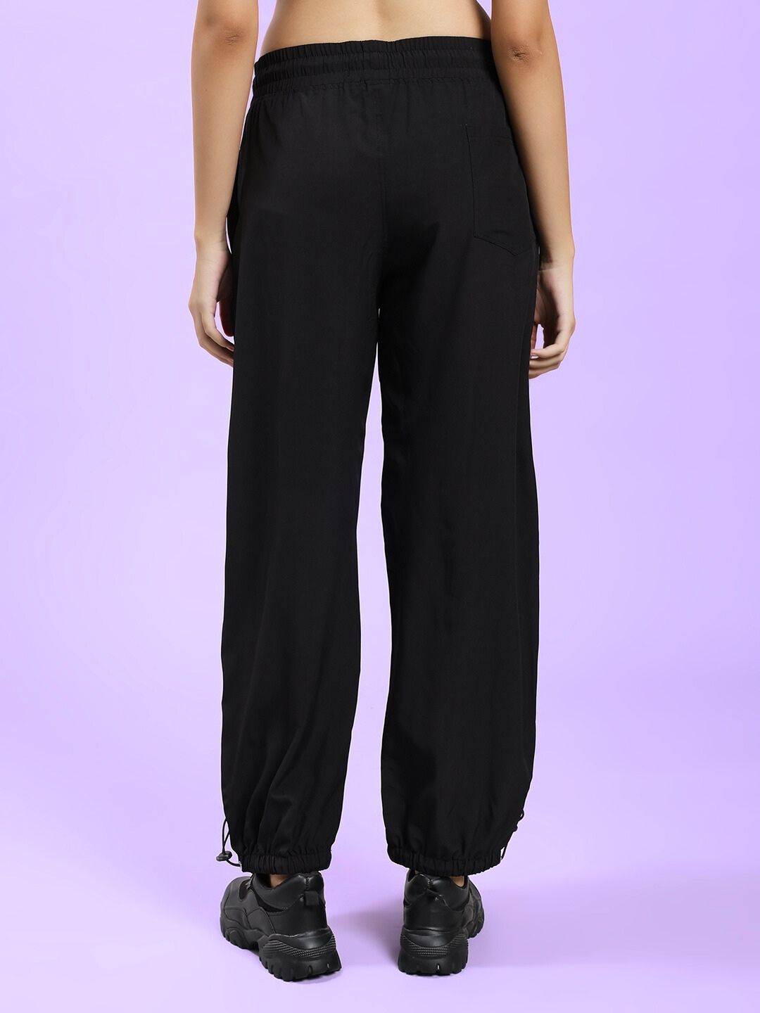Back view of WOMEN'S UNISON RELAXED-FIT JOGGERS BLACK RED on a model, showcasing relaxed fit and black color.