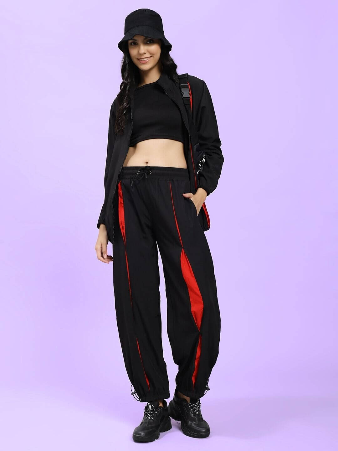 Model wearing WOMEN UNISON RELAXED-FIT JOGGERS BLACK RED with matching top and hat
