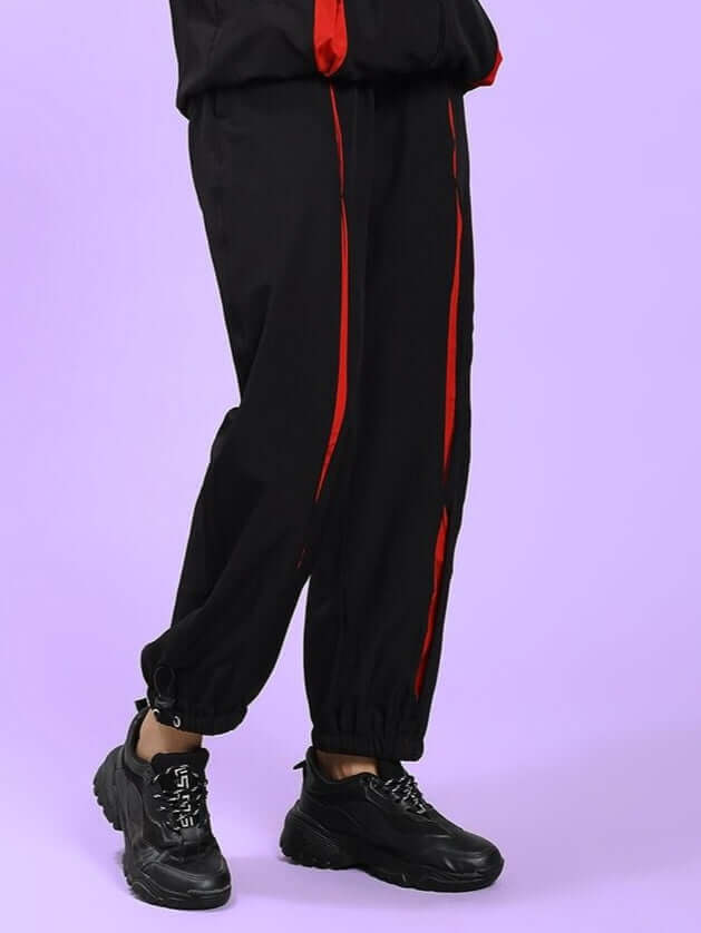 Model wearing WOMEN UNISON RELAXED-FIT JOGGERS BLACK RED with black sneakers