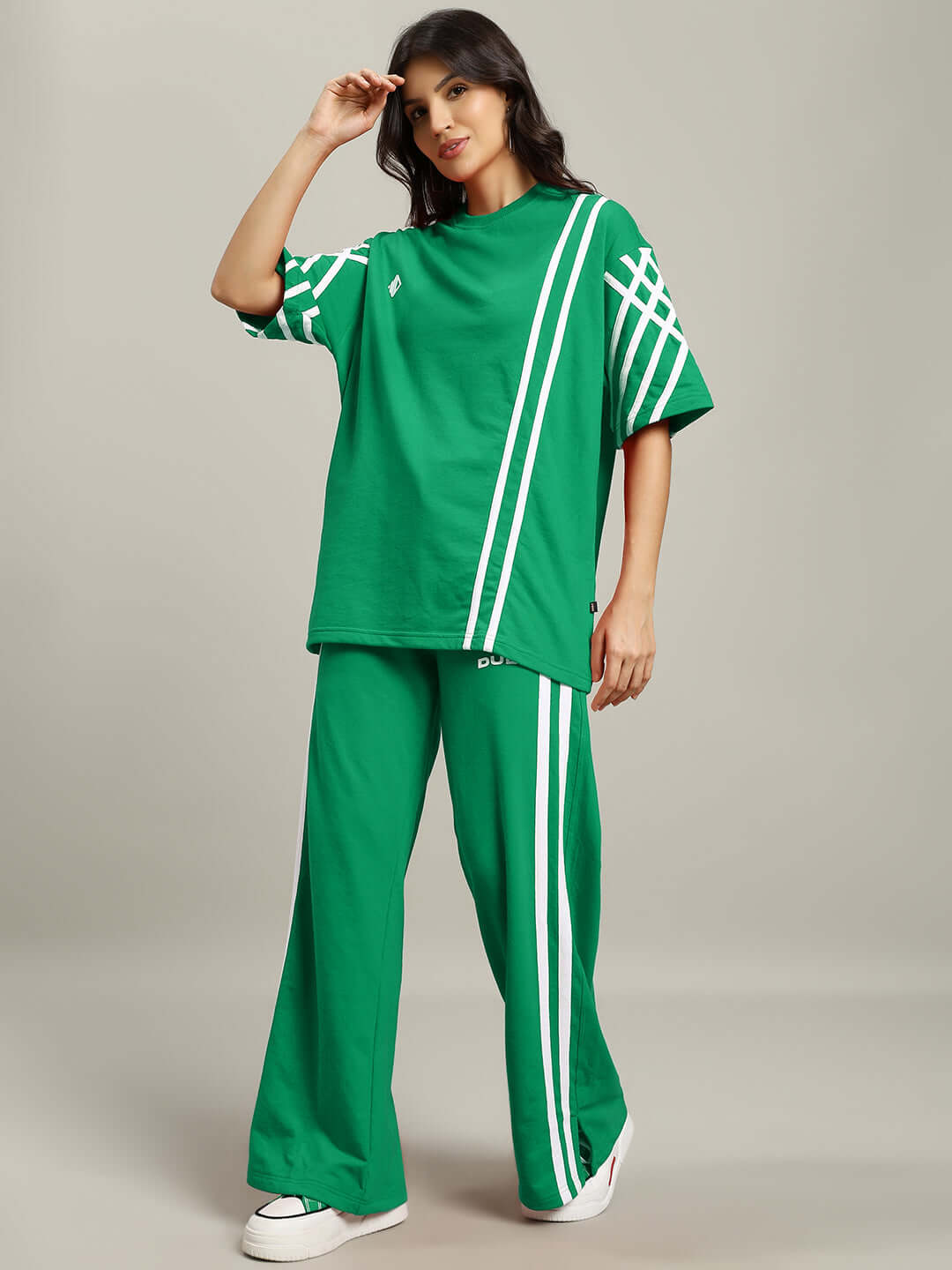 Woman wearing women's green co-ord set with white stripes, composed of premium cotton terry lycra fabric, made in India.