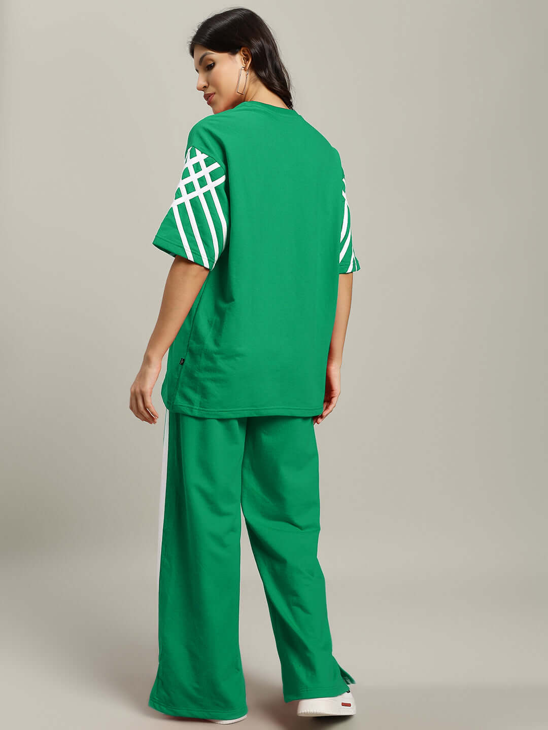 Woman wearing green Women's United Stripe Co-Ord Set made of premium cotton French terry lycra, showcasing back view.