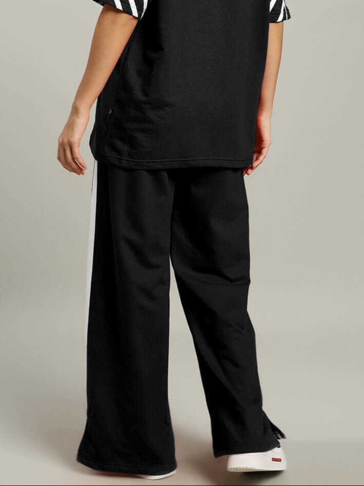 Model wearing black women's United Stripe joggers, made-to-order by DUDS, featuring customizable fit and comfortable fabric.