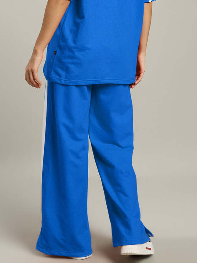 Back view of women's United Stripe joggers in blue with white stripe, showcasing relaxed fit and premium tailoring by DUDS.