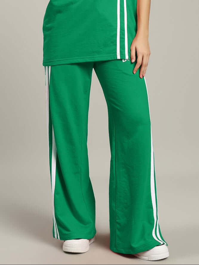 Green women's stripe joggers from DUDS, showing full-length pant style and white side stripes.