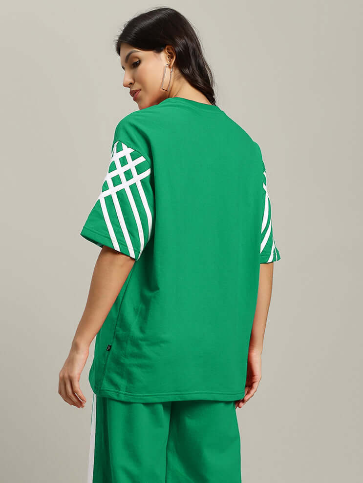 Woman wearing green striped oversized t-shirt, premium heavy gauge fabric, by Color By Colours, side view, casual fashion.