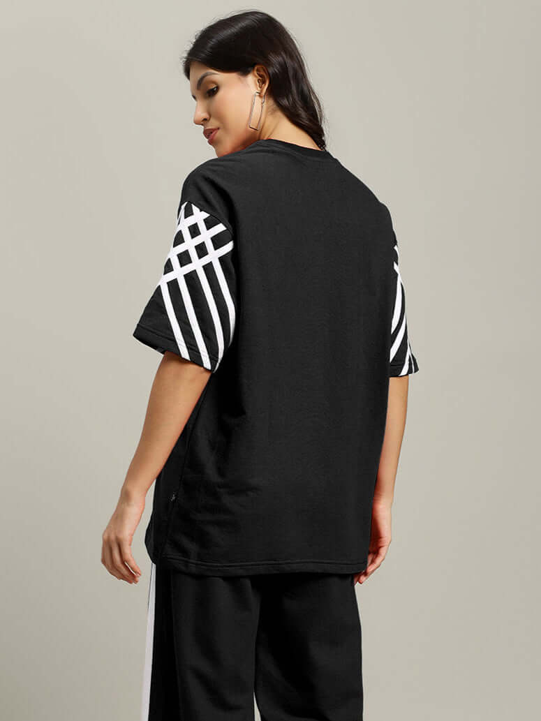 Women's oversized black T-shirt with white stripes, premium cotton fabric, rear view. Stylish casual wear. Made in India.