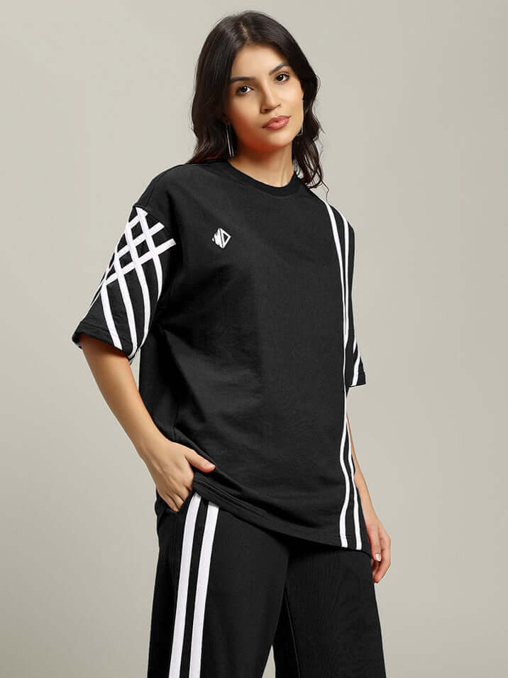 Model wearing black women's united stripe oversized t-shirt with white stripes, made of premium cotton French terry, by Color By Colours.