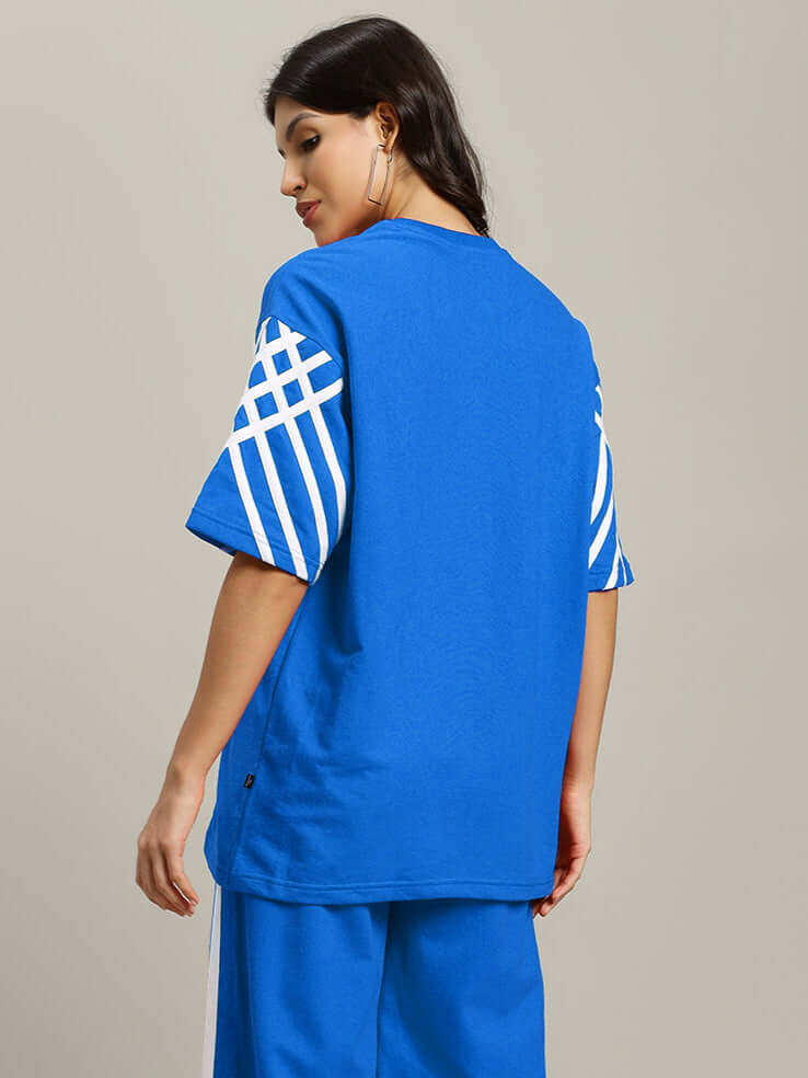 Woman wearing blue oversized women's stripe T-shirt, made of premium cotton French terry, showcasing back design, by Color By Colours.