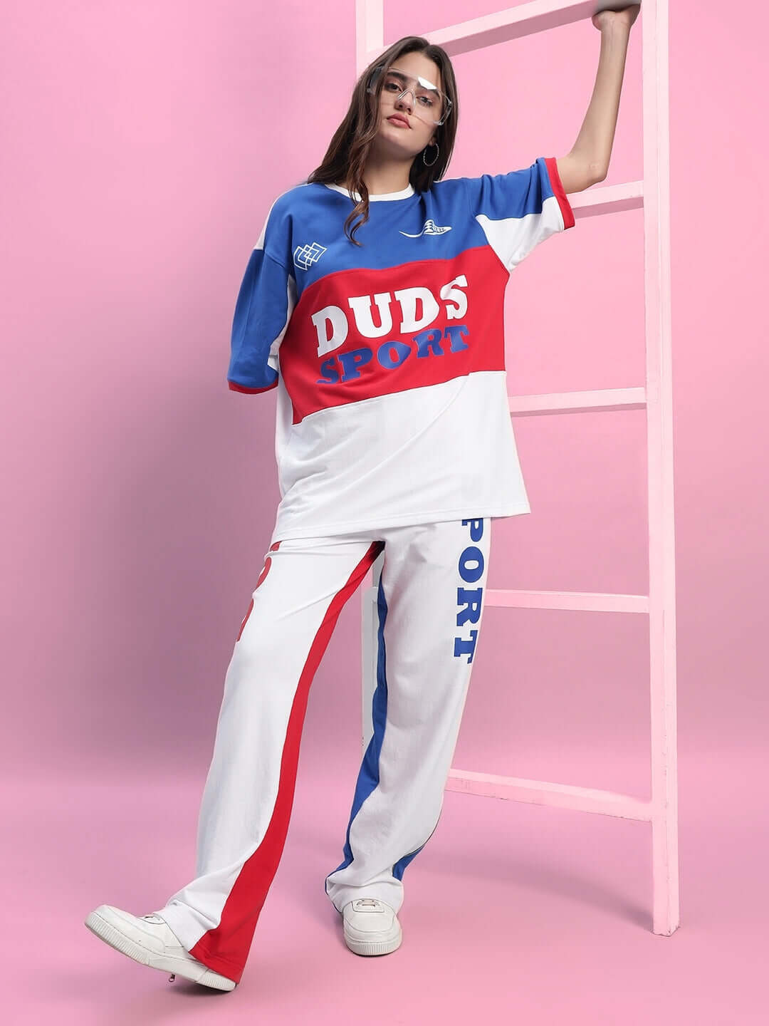 Model wearing WOMEN'S URBAN DRIFT CO-ORD SET MULTI with bold colors against a pink backdrop.