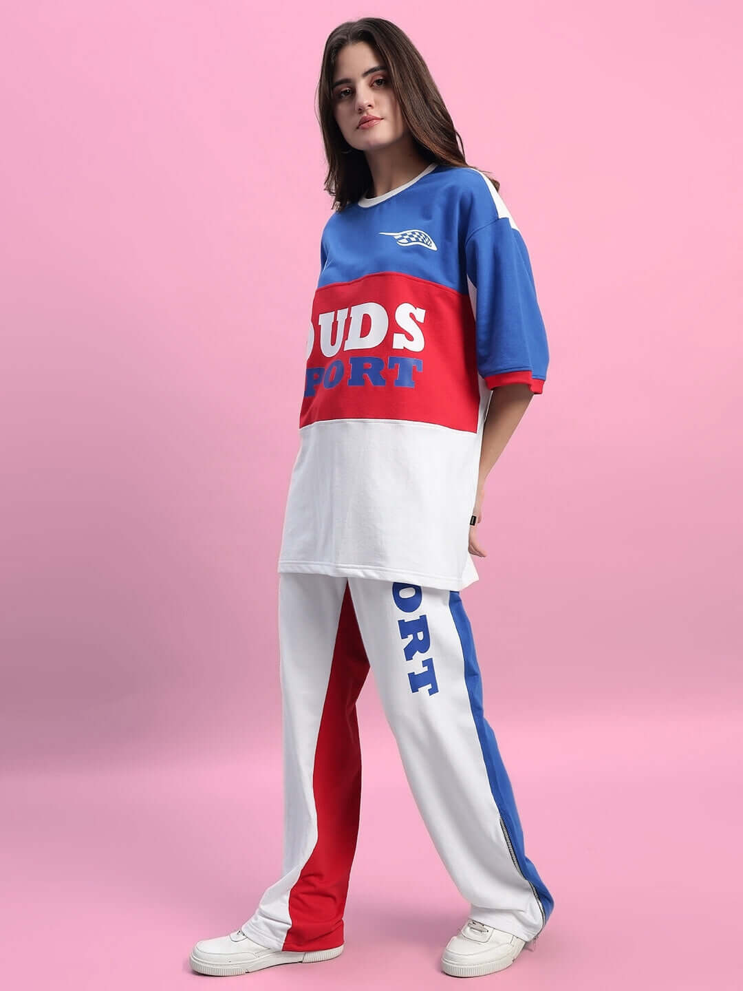 Model wearing WOMEN'S URBAN DRIFT CO-ORD SET MULTI in bold blue, red, and white colors against pink background