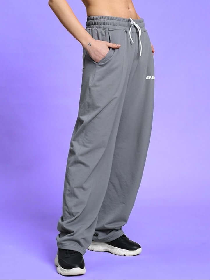 Model wearing women's vanilla relaxed-fit joggers in grey with drawstring waist and side pockets, highlighting comfortable fit and style.