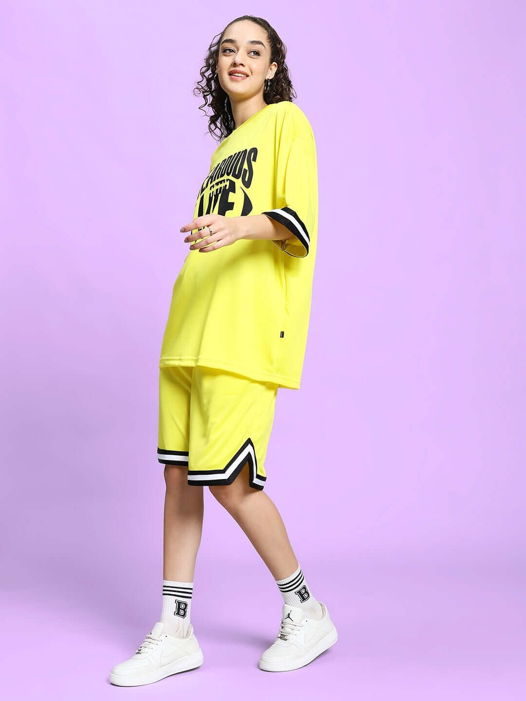 Woman wearing WOMEN'S VIGOR COLORBLOCK CO-ORD SET YELLOW in polyester fabric with sporty design.