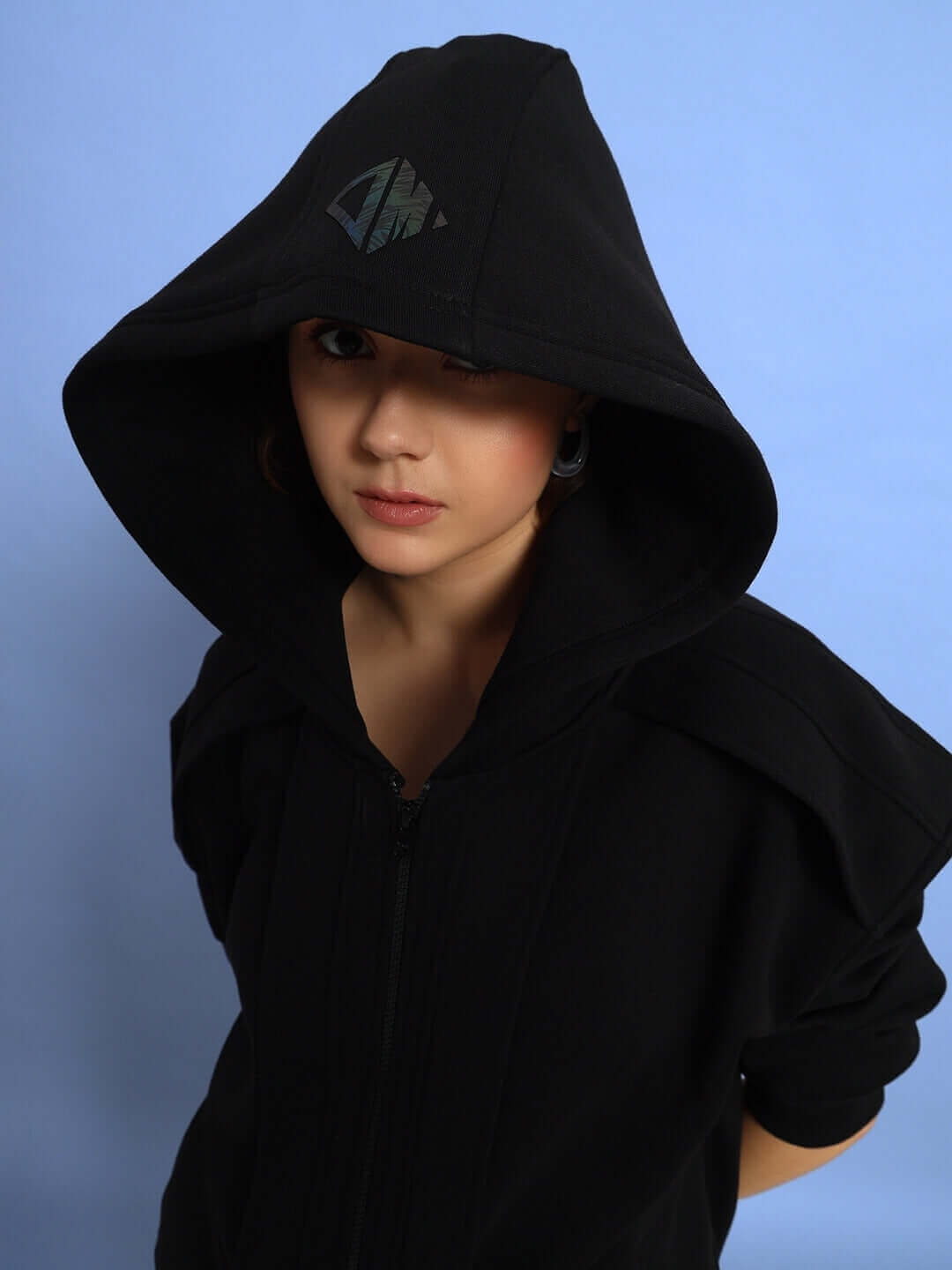 Woman wearing Women's WD Admire Co-ord in black with hood up against blue background, highlighting stylish DUDS design.