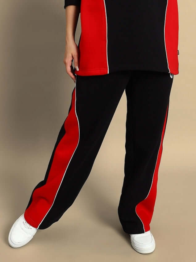 Women's black and red colorblock cargo pants with white sneakers, front view.