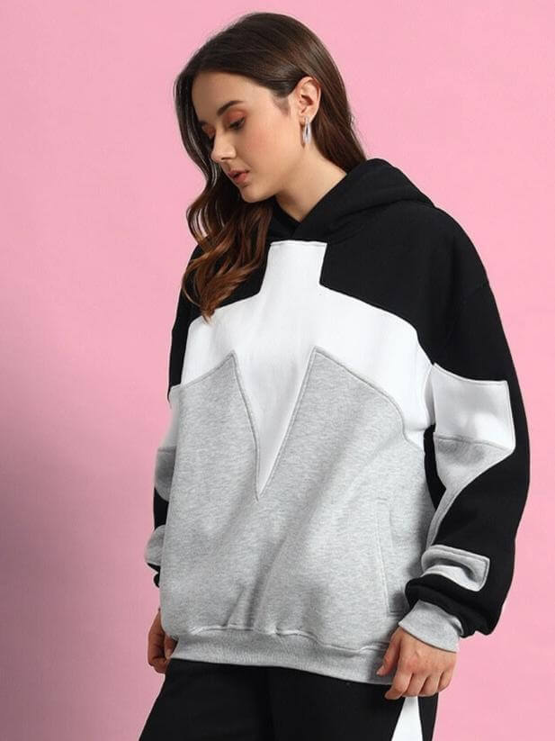 Woman wearing WOMEN WD SWORD FLEECE COLORBLOCK HOODIE BLACK GREY, featuring black and grey design with soft fleece material.