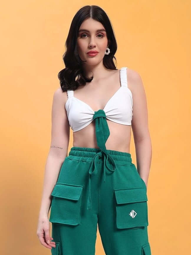 Woman wearing a stylish outfit featuring a white crop-top and green pants, perfect for a casual, trendy look.