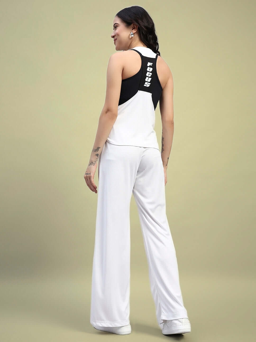 Model wearing WOMEN'S CUBBY CO-ORD SET WHITE, featuring unisex relaxed fit joggers and elasticated waistband, back view.