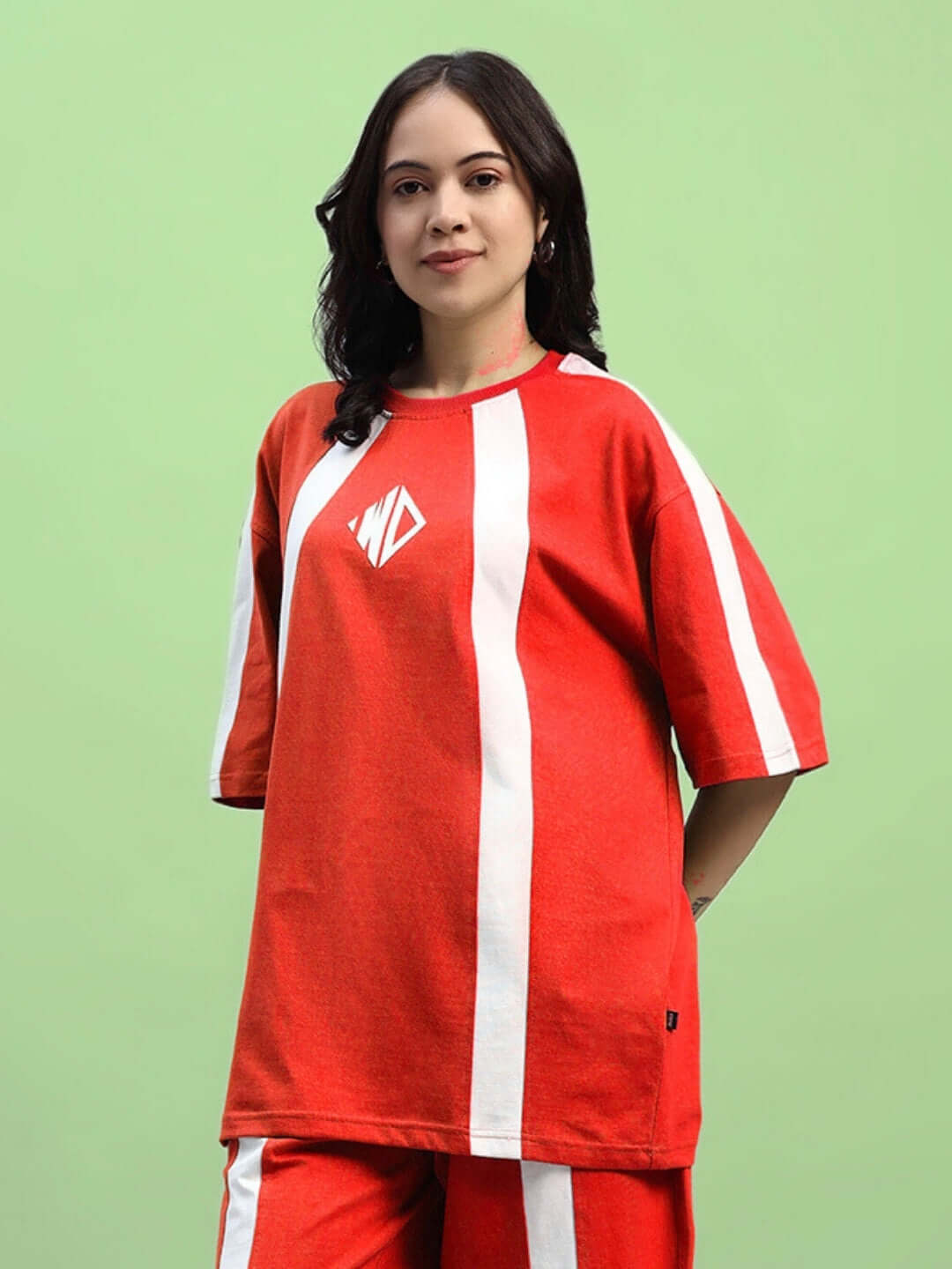 Woman wearing red oversized T-shirt with white stripes, made of premium cotton and elastane, suitable for casual wear.