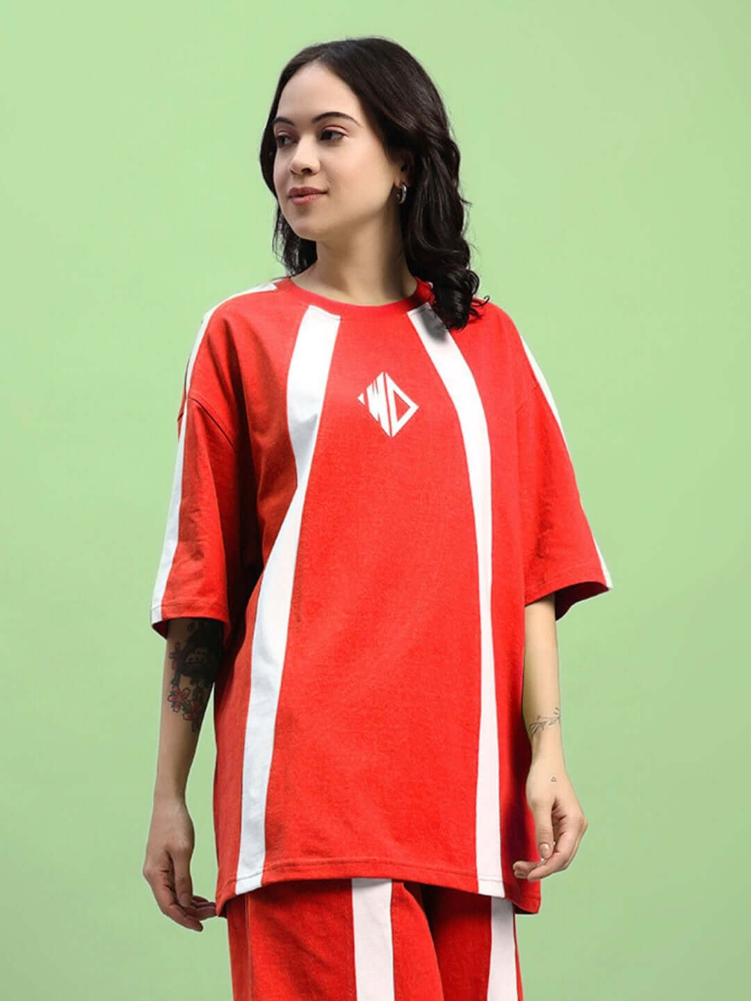 Model wearing women's red oversized T-shirt in premium cotton fabric with white stripes, emphasizing casual and stylish comfort.