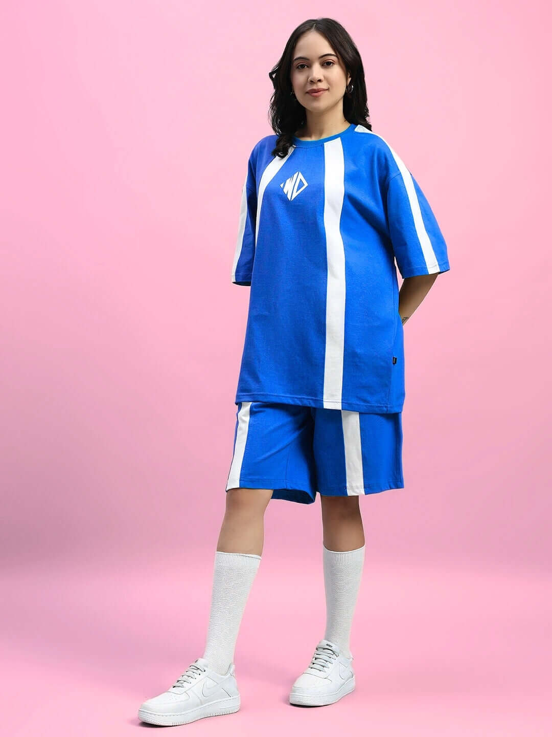 Woman wearing WOMENS WIDELINE SUMMER CO-ORD SET BLUE, featuring a blue oversized t-shirt and matching shorts with white stripes.