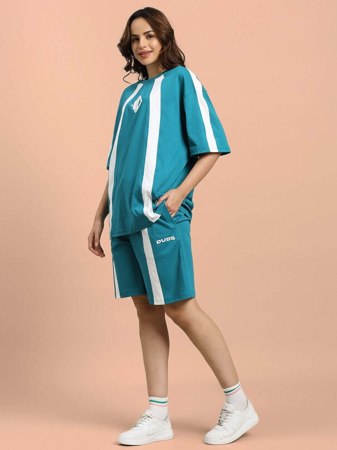 Model wearing WOMEN'S WIDELINE SUMMER CO-ORD SET TEAL, featuring teal top and shorts with white stripes, casual summer outfit
