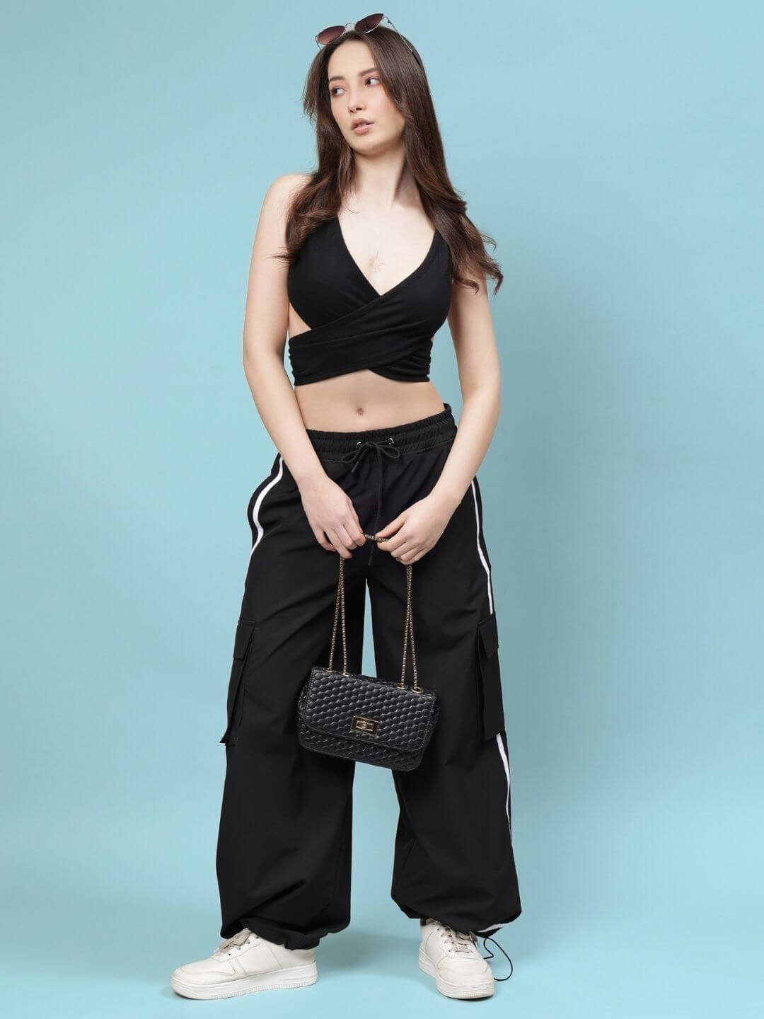 Woman wearing WOMEN'S XAVIER CO-ORD SET BLACK from WEAR DUDS, featuring a crop top and pants, perfect for chic streetwear fashion.