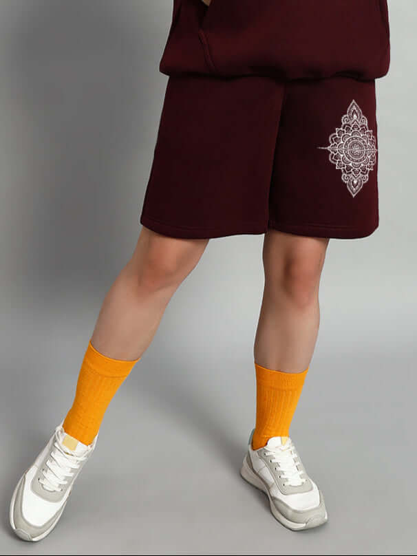 Women's Yantra Fleece Shorts Wine with custom fit option available, worn with bright orange socks and white sneakers, showcasing unique design.