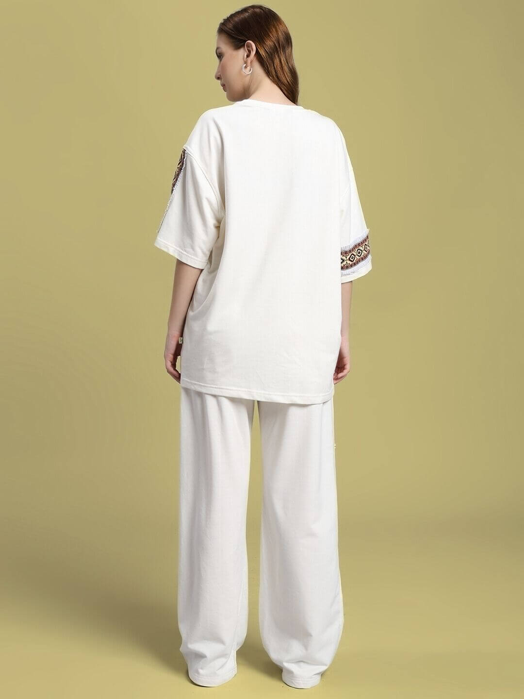 Back view of model wearing WOMEN'S YARA GEOMETRIC PRINT CO-ORD SET OFF-WHITE, showcasing geometric patterns on sleeves.