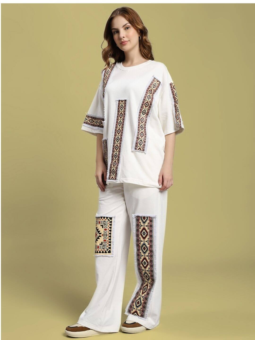 Woman wearing WOMEN'S YARA GEOMETRIC PRINT CO-ORD SET OFF-WHITE with geometric patterns on a beige background.