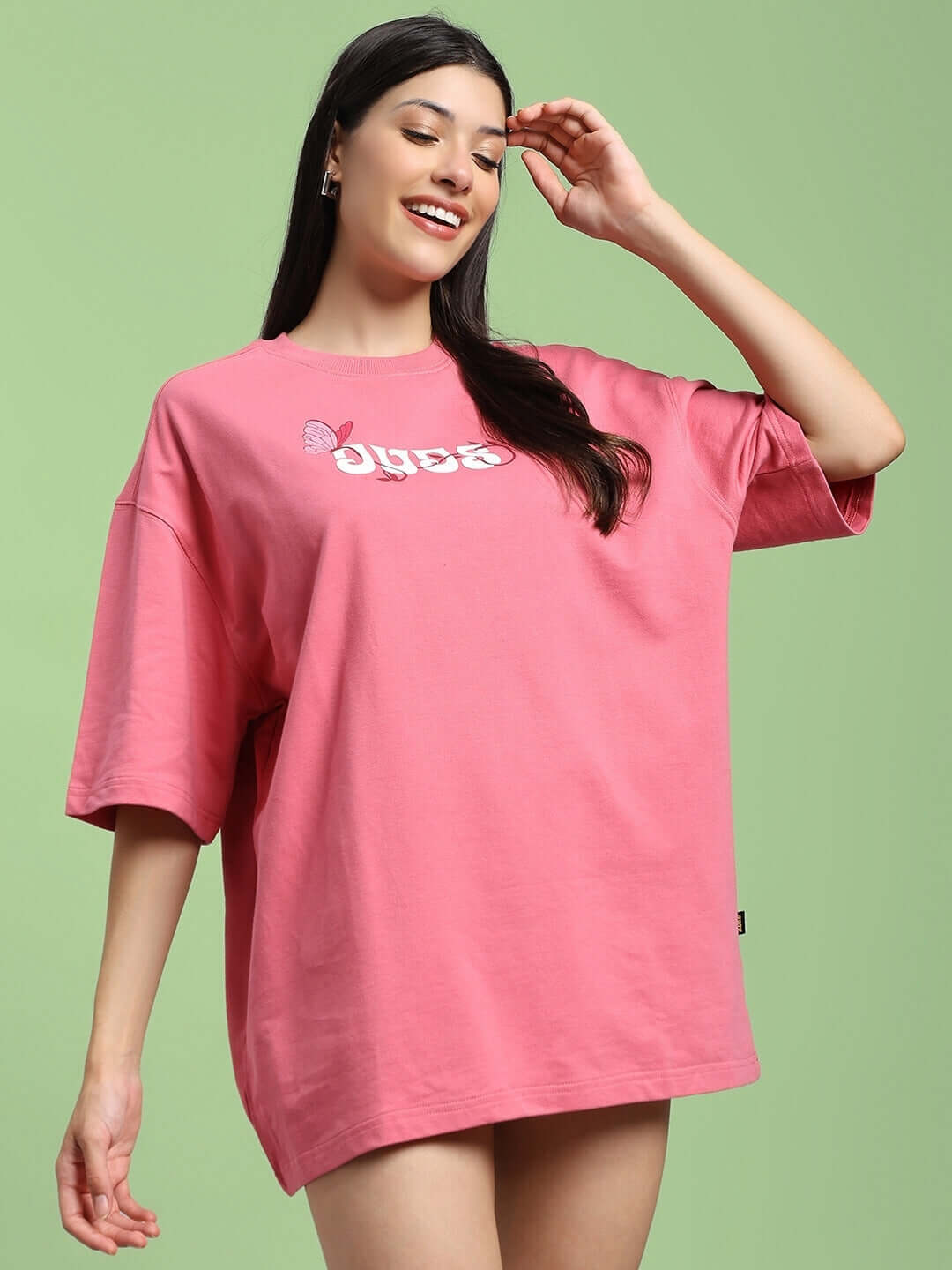 Woman wearing pink printed t-shirt made of premium cotton French terry. Stylish casual wear for women, featuring butterfly print.