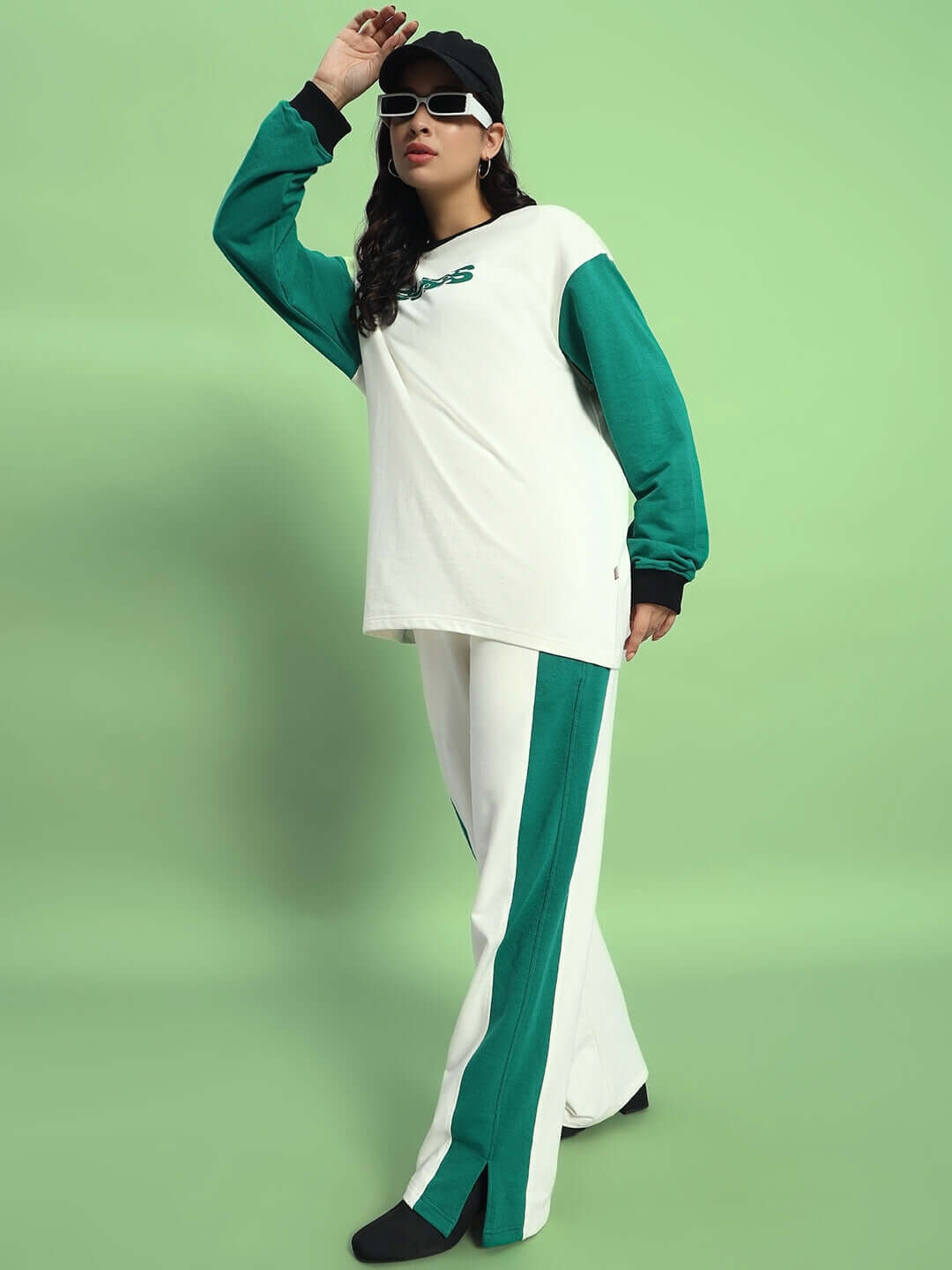 Model wearing WOMEN'S ZINGY OVERSIZED CO-ORD SET OFF WHITE TEAL with relaxed fit joggers against green background