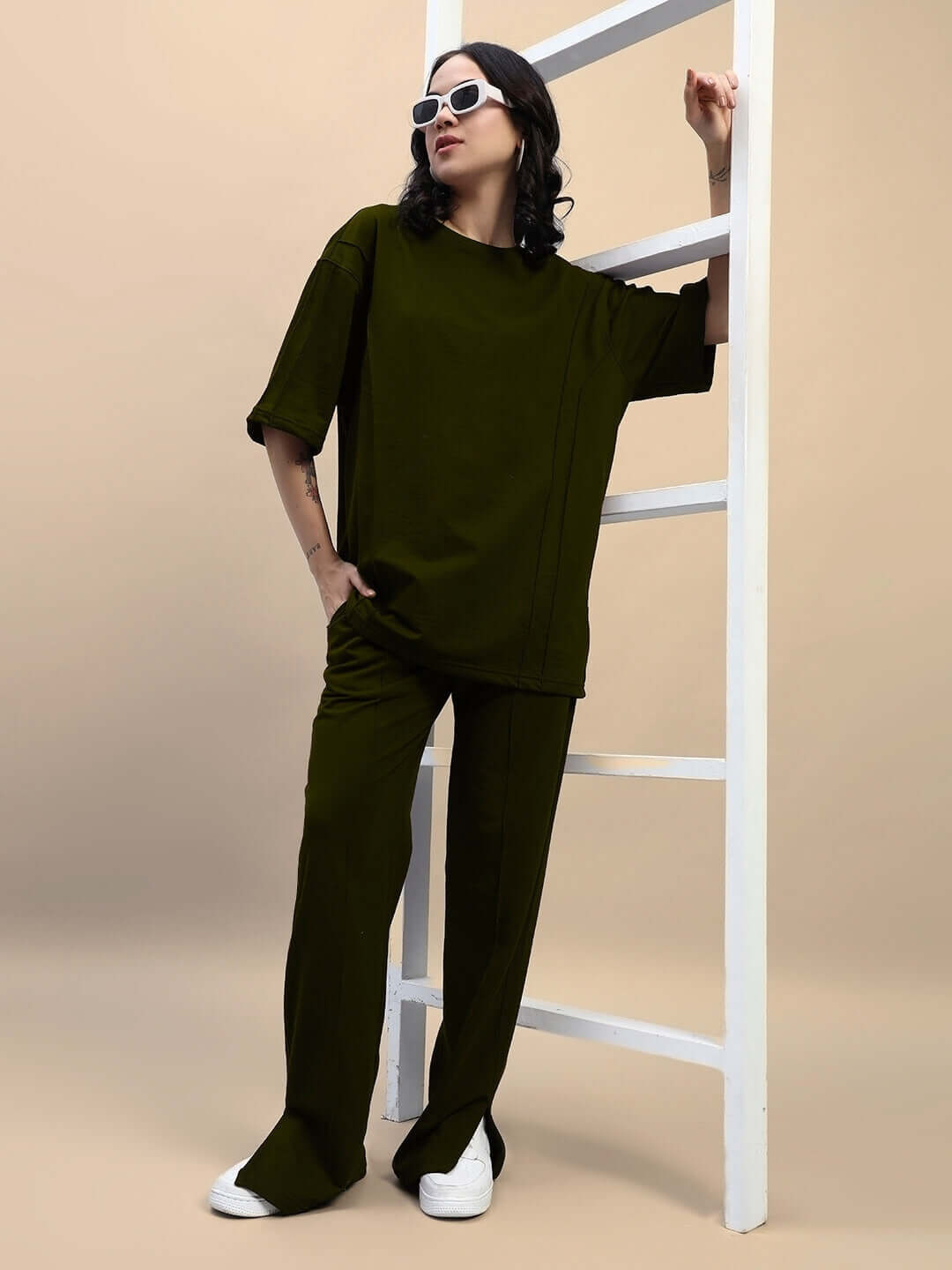Model wearing Women's Zion Relaxed Fit Co-ord Set in olive green, featuring unisex joggers and T-shirt, styled with sunglasses.