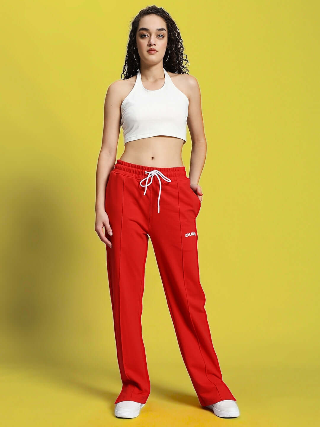 Woman wearing red Zion side slit joggers by DUDS, featuring custom fit options, made to order by experienced tailors.
