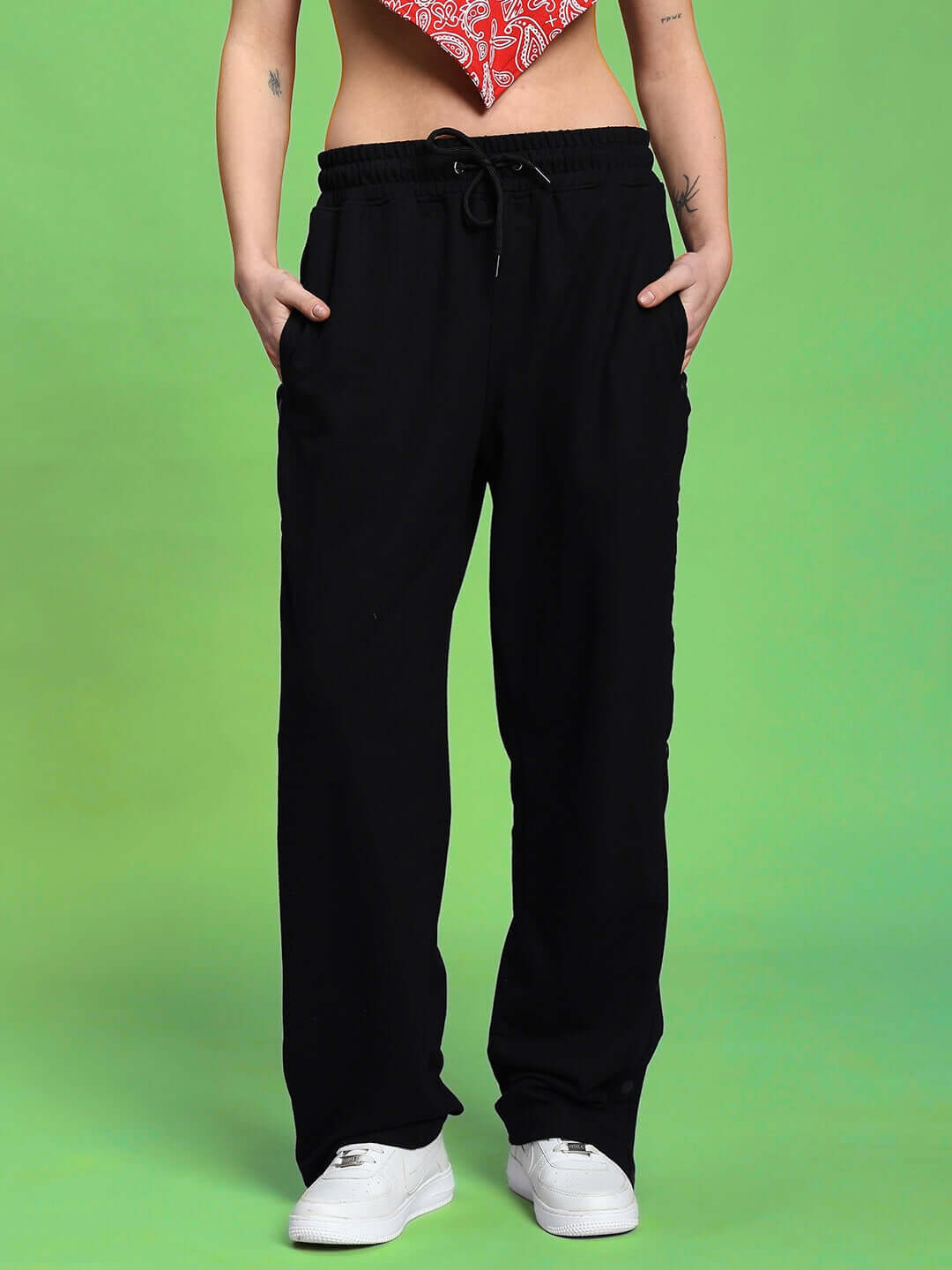 Model wearing WOMEN'S ZIVA CO-ORD SET RED-BLACK, highlighting premium breathable cotton pants with a vibrant design on a green background.
