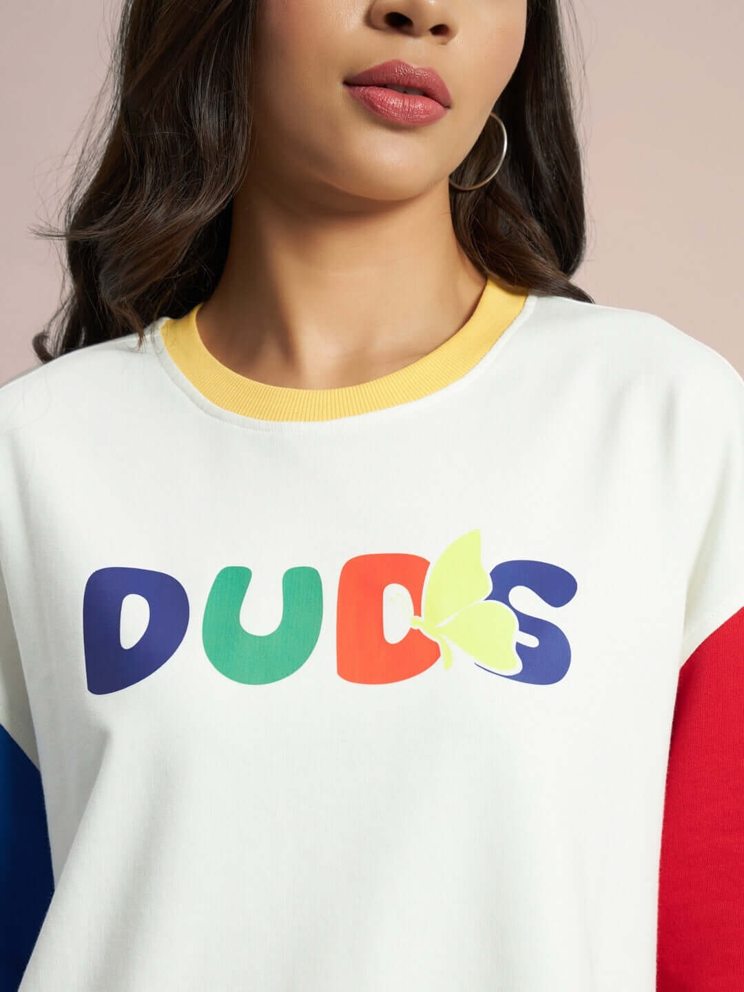 Model wearing women's Adonis color blocked oversized T-shirt in off white, featuring colorful lettering and premium cotton fabric.