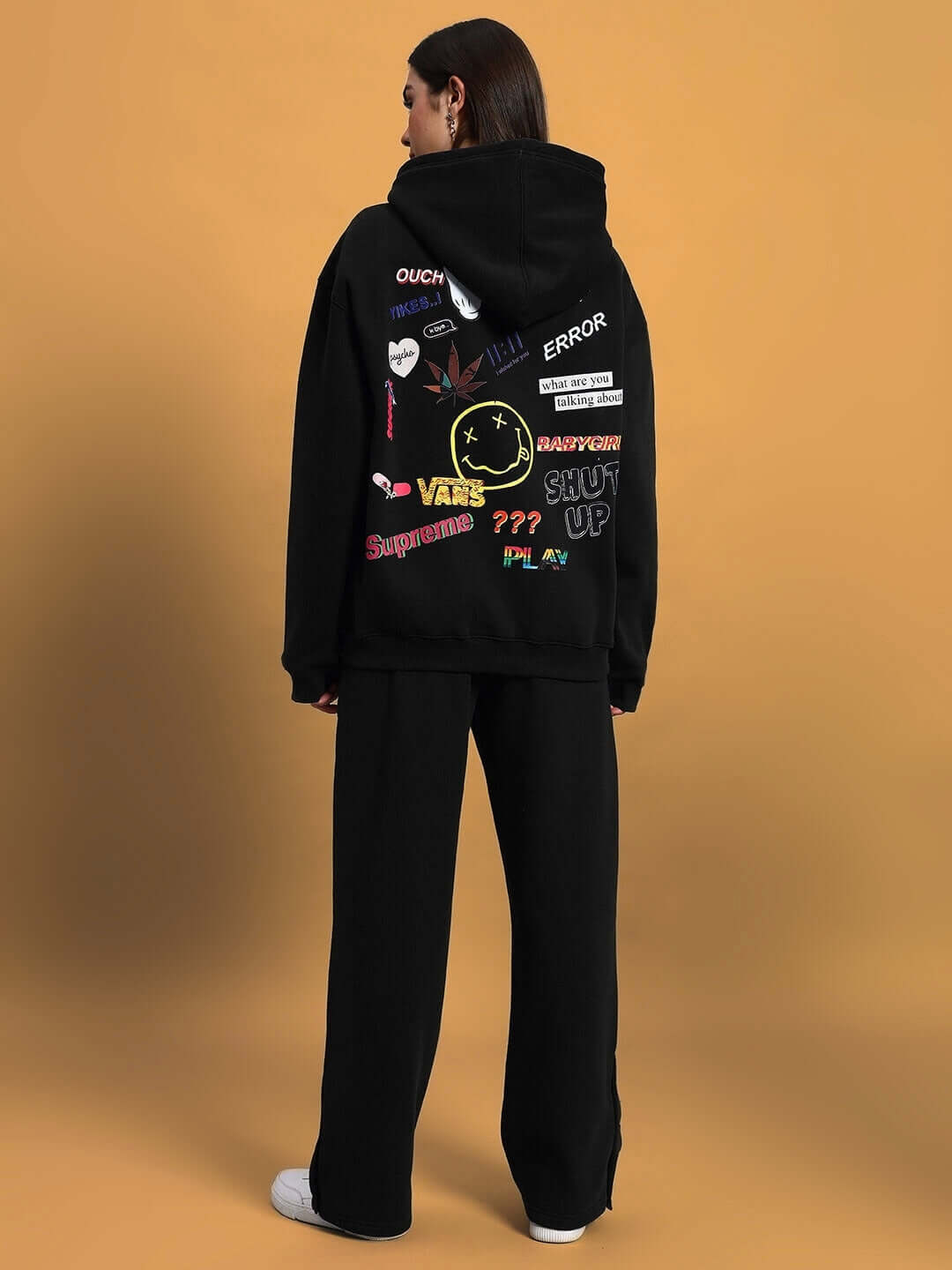 Back view of model wearing WOMEN'S SOOTY FLEECE CARGO PANT BLACK paired with graphic hoodie.