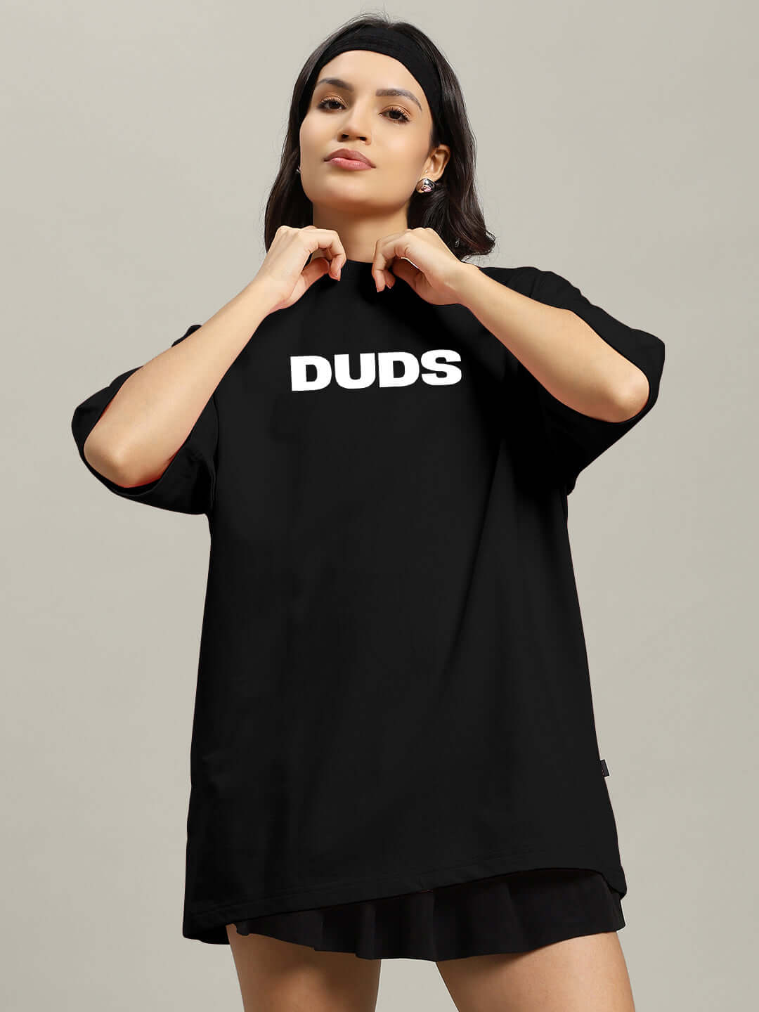 Woman wearing black oversized T-shirt with 'DUDS' text, made from premium cotton French terry, stylish and casual apparel.