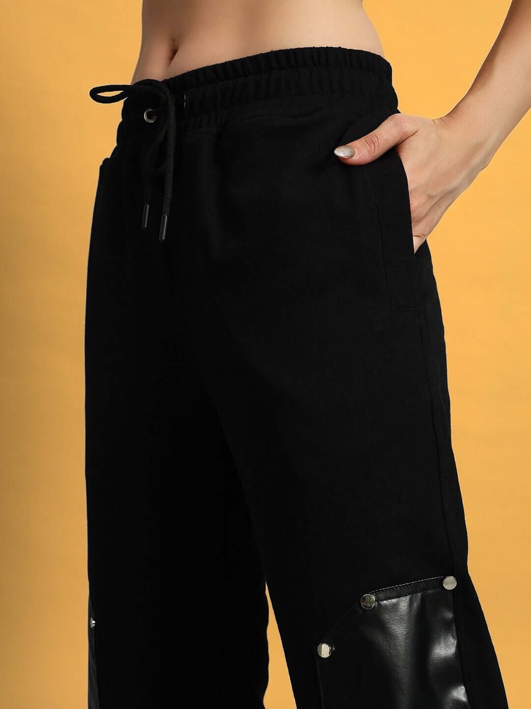 Model wearing black women's raccoon leather patch joggers, showcasing comfortable fit and stylish design for a modern look.