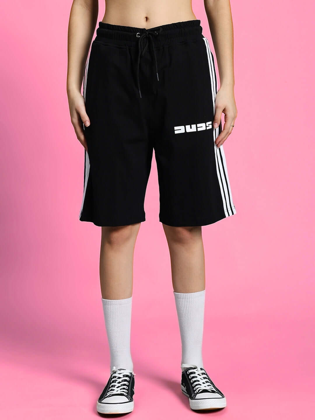Women's black summer parka shorts with white stripes, premium cotton blend, stylish co-ord set, against a pink background.